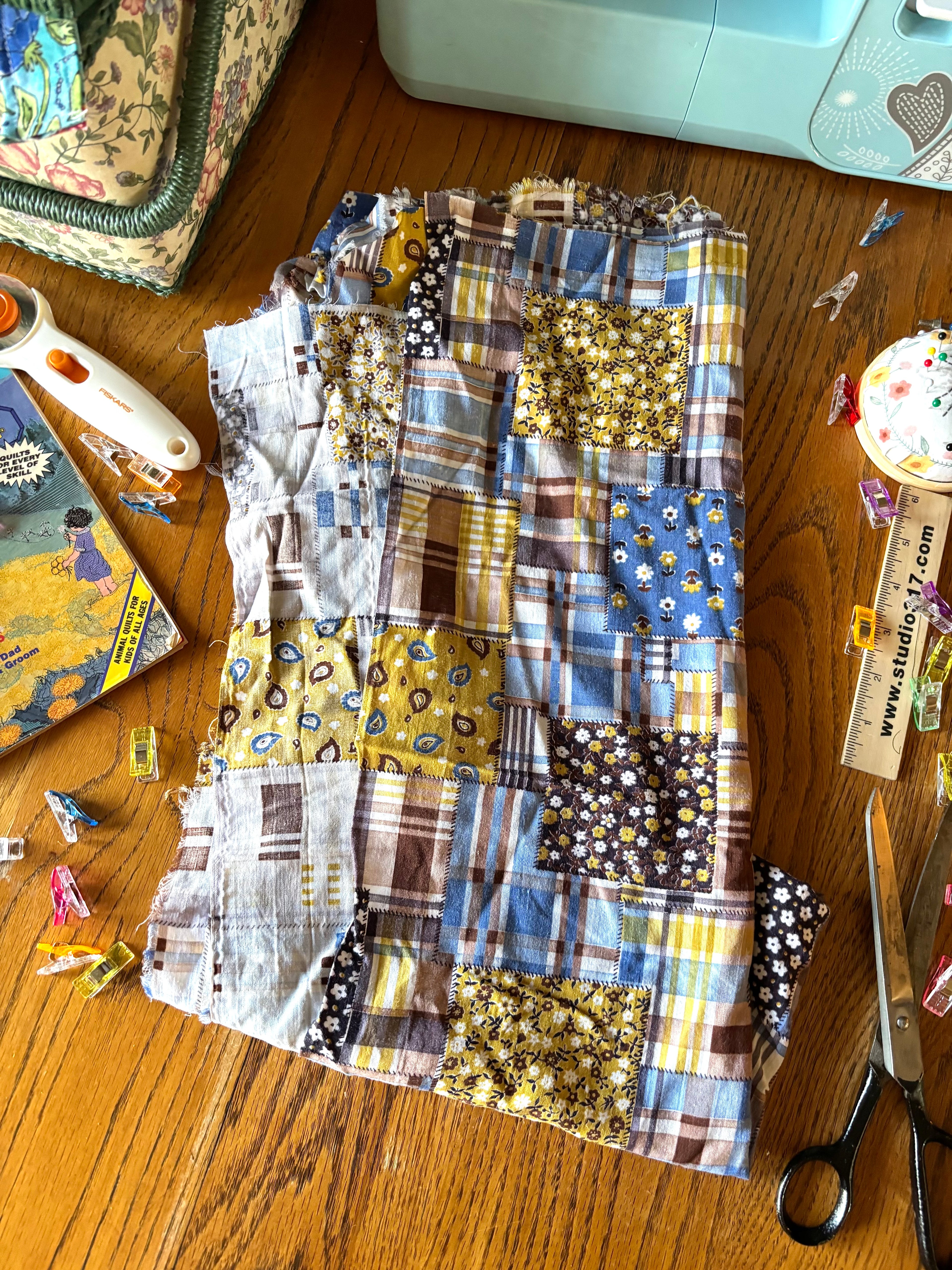 Patchwork fabric on a wooden surface with sewing tools